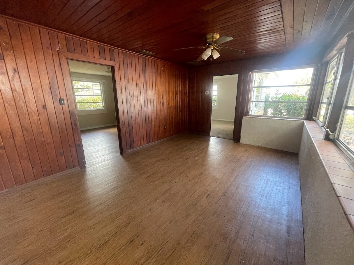 Family room before renovation — original wood paneling and flooring