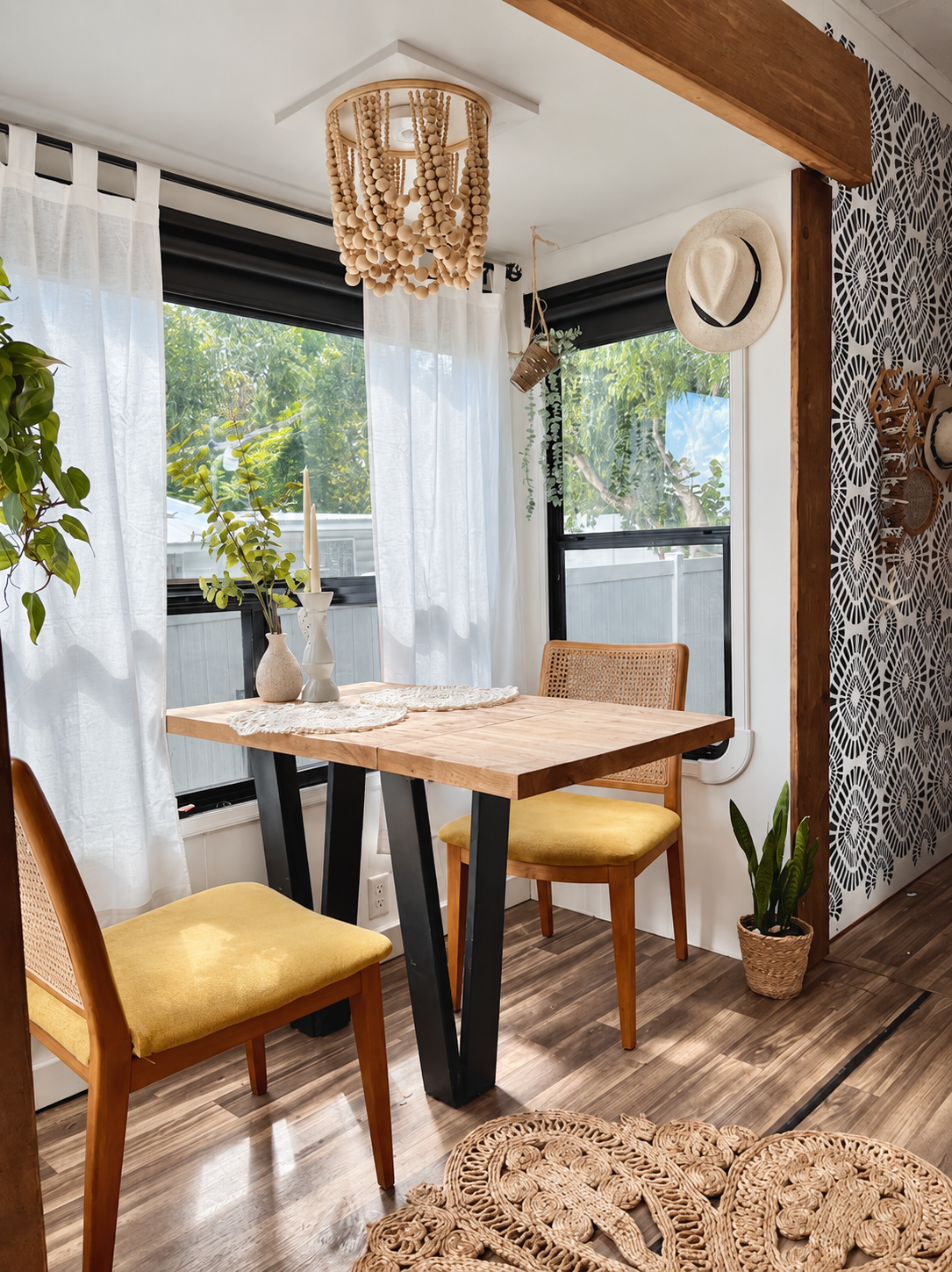 RV dining area after renovation — custom-built table, wood accents, beaded light, and design concepts