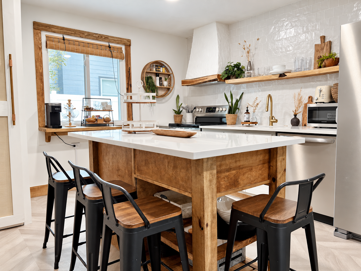 Kitchen after renovation by Madeira Studios — custom island and open shelving